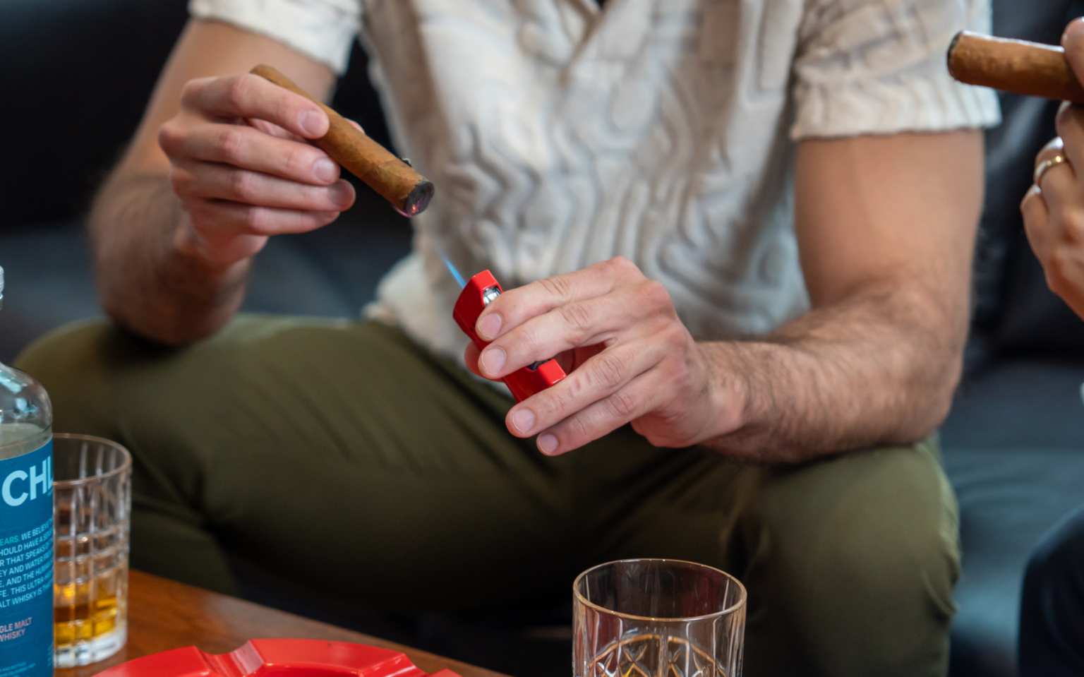 Lighting a cigar with a red LUMO lighter